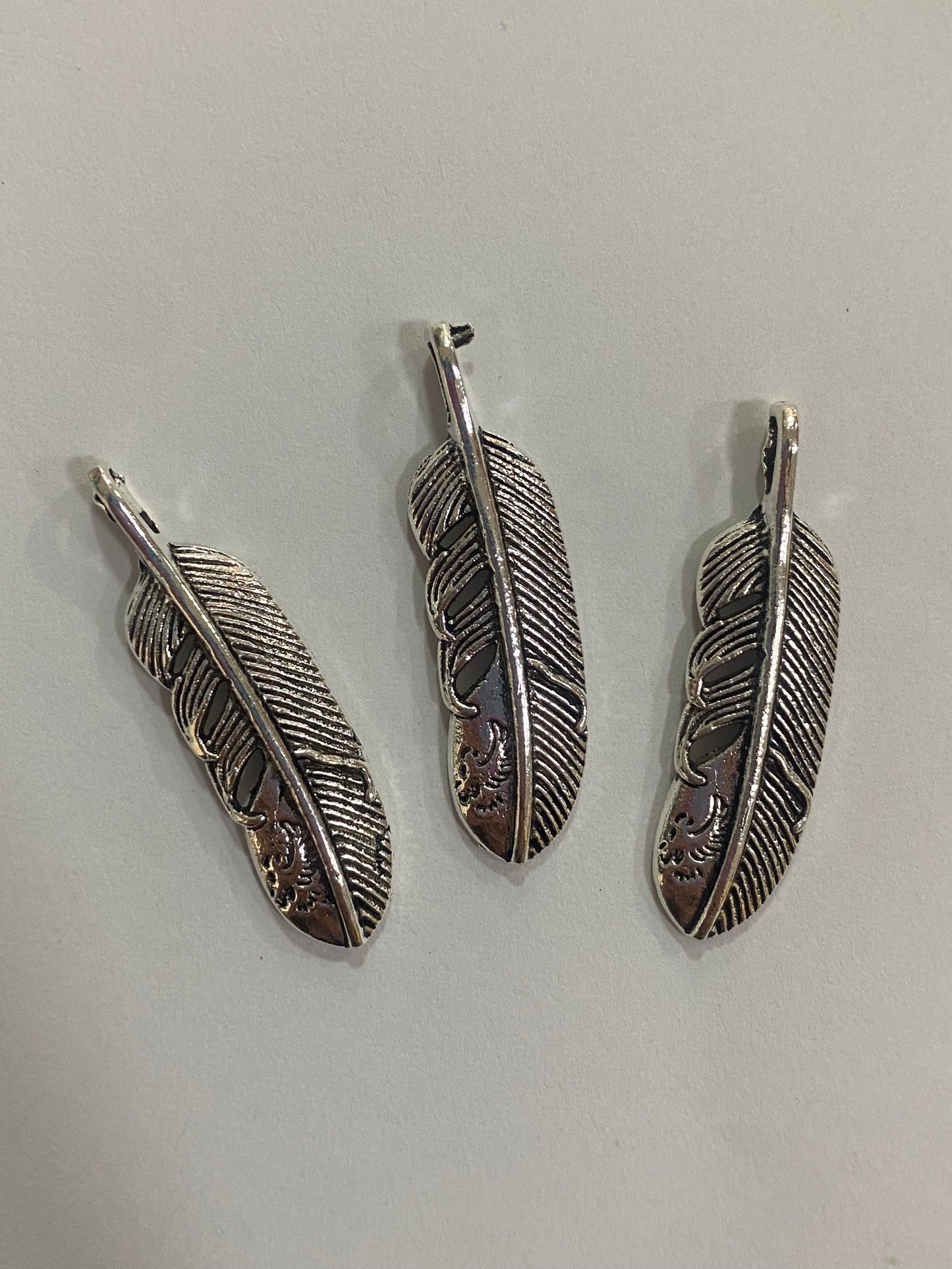 Dijes de pluma plateados 4 cm de largo
