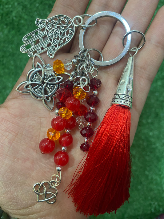 Llavero en tonos rojos con mano de Fátima y nudo de bruja plateados