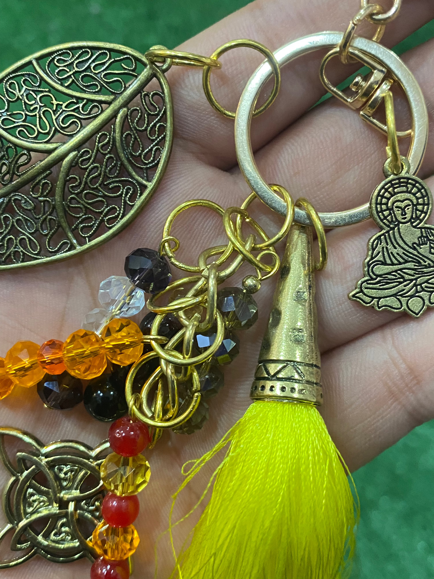 Llavero en tonos amarillos con hoja, nudo de bruja y buda